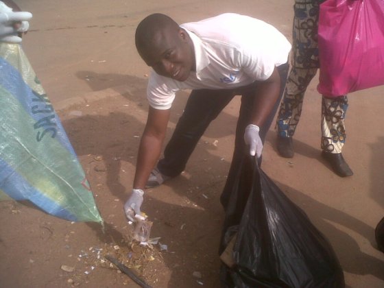 National Executive Secretary JCI Nigeria, JCIN Amb George Onuma at Utako village picking dirts as part of the clean up exercise.