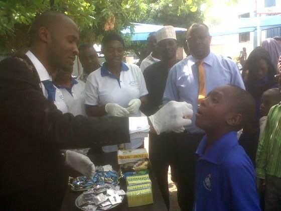 National President JCI Nigeria JCIN Amb Oyebanjo Okunuga deworming a student of Nurul BAYAN Intl Academy while other members watch during the Area C 29th Conference hosted by JCI Abuja Unity .